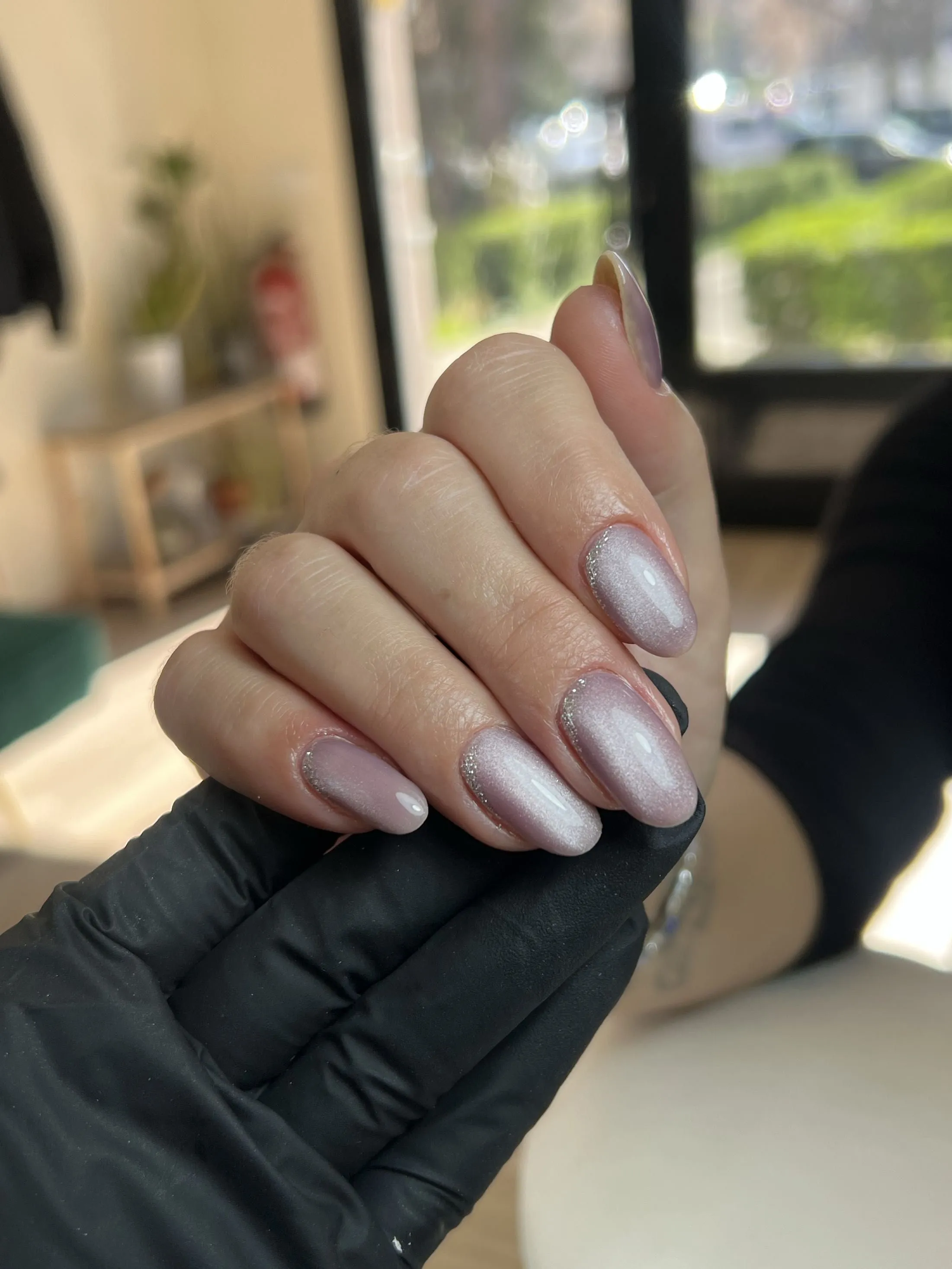 Uñas almendradas con efecto cat eye en tono lila perlado